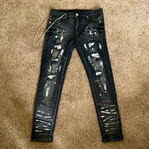 Black denim jeans with white and yellow paint splatter